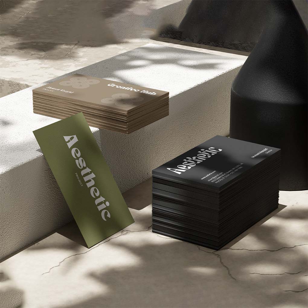 Stacks of thick premium business cards with black green and neutral designs