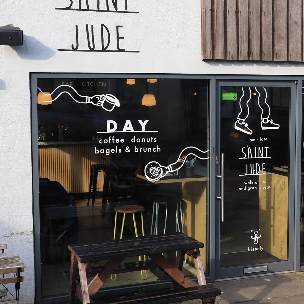 Custom white vinyl cut stickers and window graphics for cafe storefront branding in Dubai